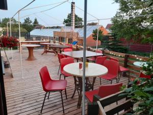 a patio with tables and red chairs on a deck at Voodikoht Viljandis in Viljandi