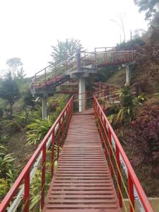 a red bridge with a red railing on a hill at Vamoose Rainbow Valley Resort in Sonāda
