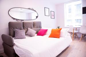 a bedroom with a large bed with colorful pillows at New West End Apartments by Indigo Flats in London