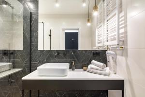 a bathroom with a sink and a mirror at Homewell Boutique Apartments in Poznań