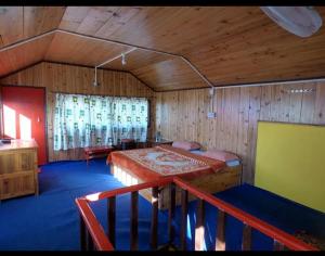 a bedroom with a bed in a room with wooden walls at Rainbow Valley Resort in Sonāda