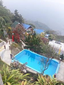 a large blue swimming pool in front of a house at Vamoose Rainbow Valley Resort in Sonāda