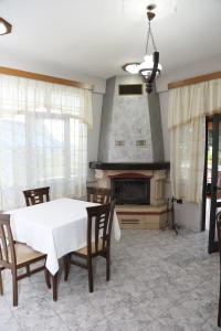 a dining room with a table and a fireplace at Hotel Villa Kabashi in Korçë