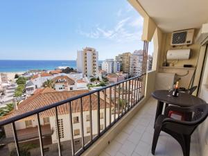 balcón con mesa y vistas al océano en Apartamento Praia Rocha Vista Mar Ambar en Portimão
