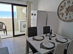 comedor con mesa con sillas y nevera en Apartamento Praia Rocha Vista Mar Ambar en Portimão