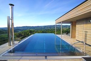 a swimming pool on the side of a house at Mahorko Wein Wellness Wasserbüffel in Glanz an der Weinstraße