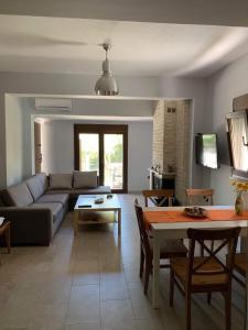 ein Wohnzimmer mit einem Sofa und einem Tisch in der Unterkunft Villa Maria 2 in Toroni