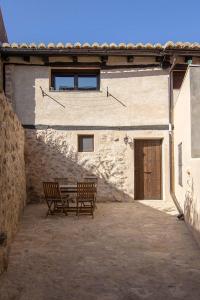 dwie ławki siedzące przed budynkiem w obiekcie Casa Barrena w Albarracín