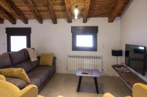 a living room with a couch and a tv at Casa Barrena in Albarracín