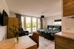 a living room with a bed and a couch at Hofwestdijk in Vrouwenpolder