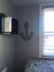 a bedroom with a bed and a anchor on the wall at Southville Guest House in Weymouth