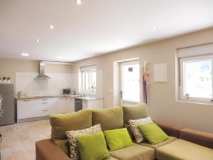 a living room with a couch and a kitchen at El Corro, acogedora casa con jardín en el corazón de Cantabria in Villasuso de Cieza