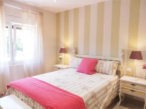 1 dormitorio con 1 cama rosa y 2 mesitas de noche en El Corro, acogedora casa con jardín en el corazón de Cantabria, en Villasuso de Cieza