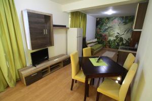 a living room with a dining room table and a kitchen at Villa Salena in Primorsko
