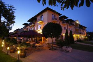 a large building with tables and chairs in front of it at Xavin Wellness Hotel & Restaurant in Harkány