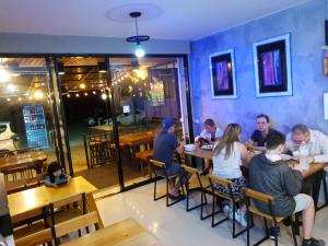 a group of people sitting at tables in a restaurant at You In House URT Surathani Airport in Ban Hua Toei