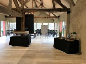 een grote kamer met tafels en stoelen in een gebouw bij Le Prieuré de Boulogne in Tour-en-Sologne