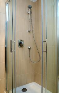 a shower with a glass door and a shower at Hotel Predium in Vráble