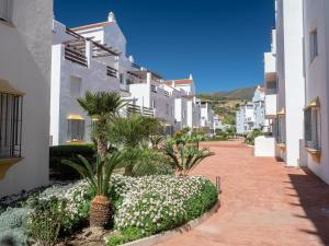una calle con edificios blancos y palmeras en 2060-Newly furnished 2 bedrooms apt with golf, en Estepona