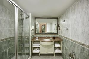 a bathroom with a sink and a shower at Delphin Deluxe Resort in Okurcalar