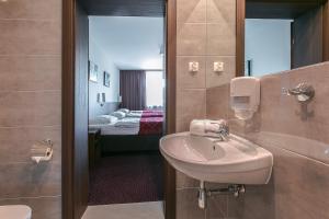 a bathroom with a sink and a room with a bed at Pod Lipami in Bystra +81 photos
