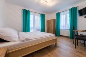 sypialnia z łóżkiem z zielonymi zasłonami i biurkiem w obiekcie Willa Nova w Polańczyku