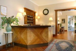 a lobby with a large wooden reception counter with a clock at Hotel Moderno in Premeno