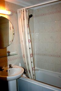 a bathroom with a sink and a shower curtain at Hartland 2-Bedroom Apartments with Bfast and Parking in Southend-on-Sea