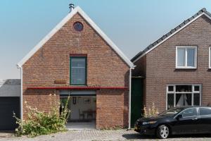 a brick house with a car parked in front of it at bnb De Loft in Kloosterzande