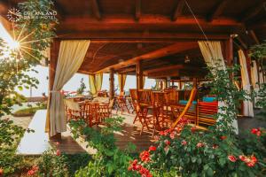 een patio met houten stoelen, tafels en bloemen bij Dreamland Oasis Hotel in Chakvi