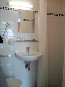 a white bathroom with a sink and a shower at Hotel 74 in Amsterdam