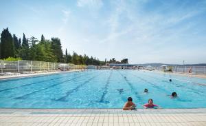 a group of people swimming in a large swimming pool at Villa Cedra - Hotel & Resort Adria Ankaran in Ankaran