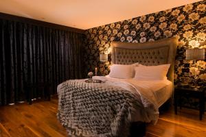 a bedroom with a bed and a wall with floral wallpaper at The Twelve Hotel in Barna