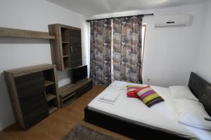 een kleine slaapkamer met een bed en een televisie bij Villa Salena in Primorsko