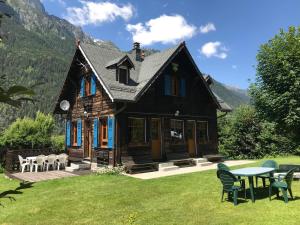 a house with a table and chairs in the yard at La Crèmerie du Vernet in Chamonix-Mont-Blanc