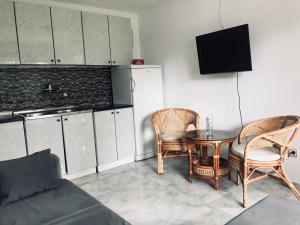 a living room with a table and chairs and a kitchen at Apartmani Konjević in Herceg-Novi