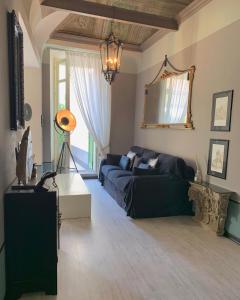 ein Wohnzimmer mit einem schwarzen Sofa und einem Spiegel in der Unterkunft Dimora dell'Antico Convento in Alba