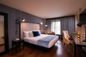 una camera d'albergo con letto, scrivania di The Twelve Hotel a Barna