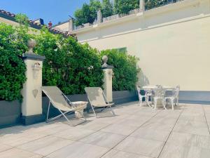 eine Terrasse mit Stühlen und einem Tisch in einem Gebäude in der Unterkunft Dimora dell'Antico Convento in Alba