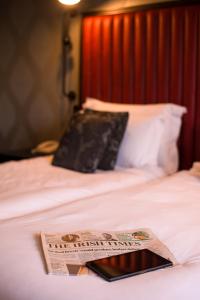 a newspaper sitting on top of a bed at The Twelve Hotel in Barna