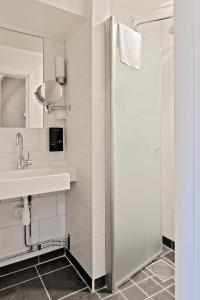 ein Bad mit einer Dusche und einem Waschbecken in der Unterkunft Skytteholm in Ekerö