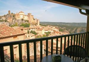 a balcony with a table and a view of a castle at Hotel Castillo in Alquézar