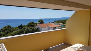 a balcony with a large window with a view of the ocean at Villa Anka in Rab