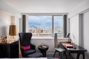 a room with a desk and chairs and a window at Sea Containers London in London