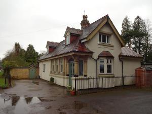 a white house with a fence in a parking lot at Victorian Gate House Own Bathroom in Solihull