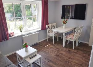 a living room with a table and chairs and windows at Reetferienhaus - Schaprode Hafen in Schaprode +46 photos