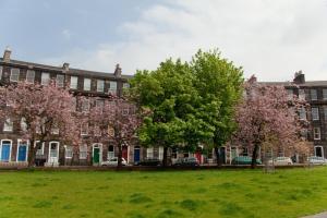 a large brick building with trees in front of it at The West End Cottage in Edinburgh