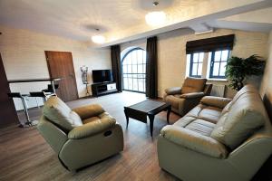 una gran sala de estar con sofás y un piano en Apartamenty Zamkowa en Pleszew