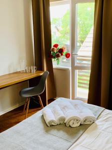 Schlafzimmer mit einem Bett, einem Schreibtisch und einem Fenster in der Unterkunft Водограй, курортна вілла in Morschyn