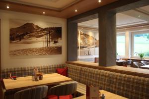 - un restaurant avec une table et des chaises dans la chambre dans l'établissement Hotel Garni Lärchenhof, à Lech am Arlberg